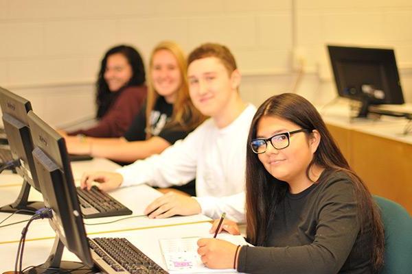 Group of students working on project at computers 